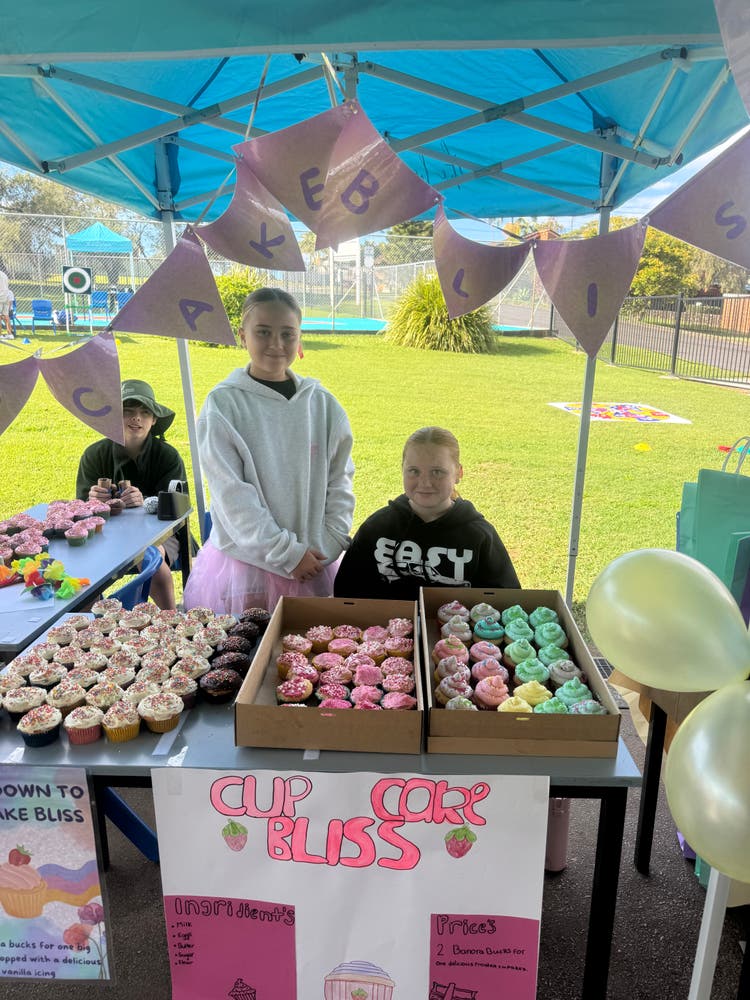 Year 6 students standing behind their cake stall at Banora Bazaar, raising funds for their Year 6 Farewell.
