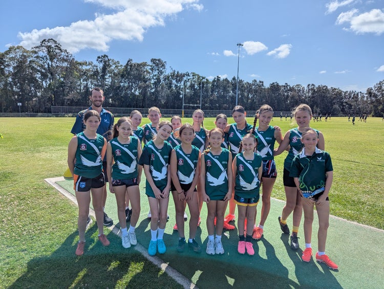 The senior touch group smiling at the camera with their coach by their side before they participate in the Touch Gala Day.