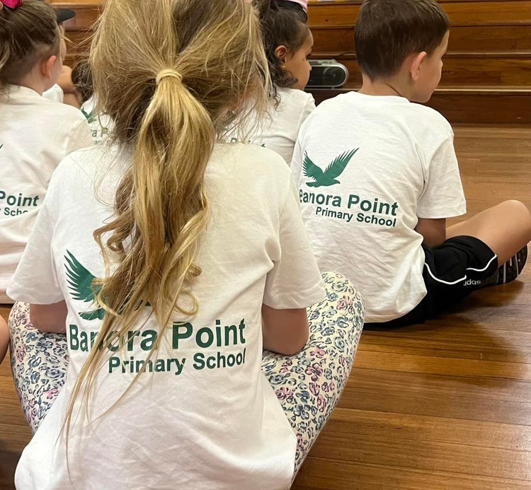 A student wearing a white Beginning at Banora t-shirt, featuring the school logo on the back.