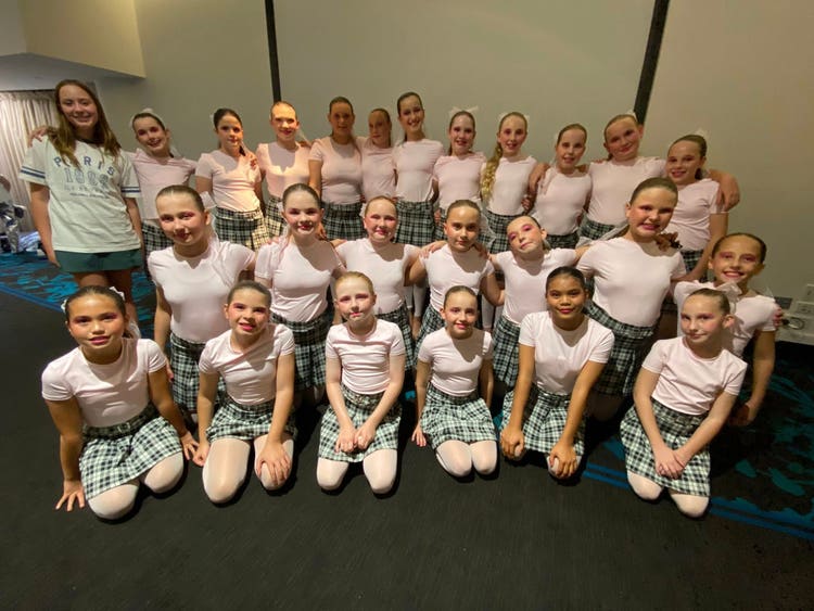 A group photo of the Senior Dance Group. They are in their dance costume which consisted of a pink t-shirt and checked skirt. The Senior Dance Group performed at the Far North Coast Dance Festival.
