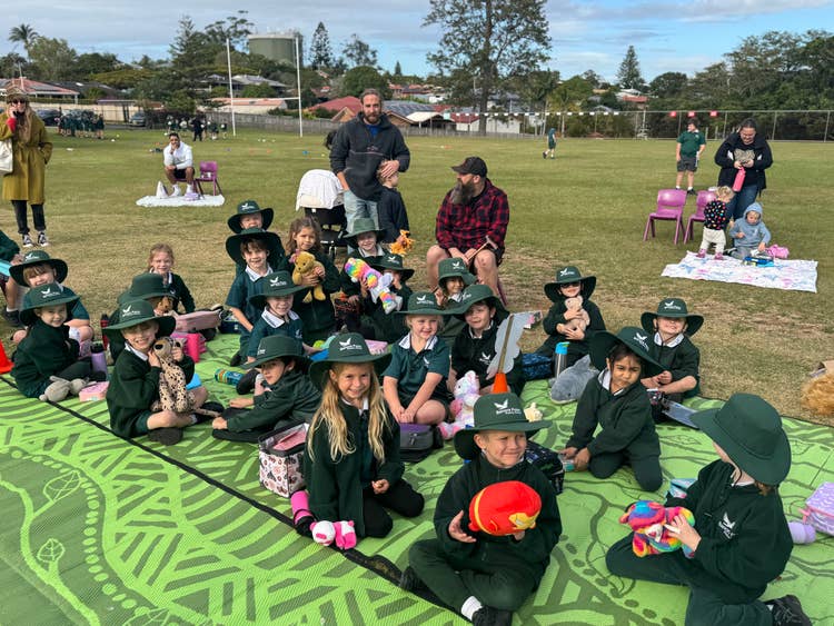A group of kindergarten students sitting on a picnic rug, each holding their favourite teddy bear, for our annual Teddy Bears Picnic.