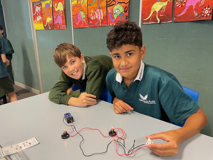 Two students collaborating to design an electric circuit.